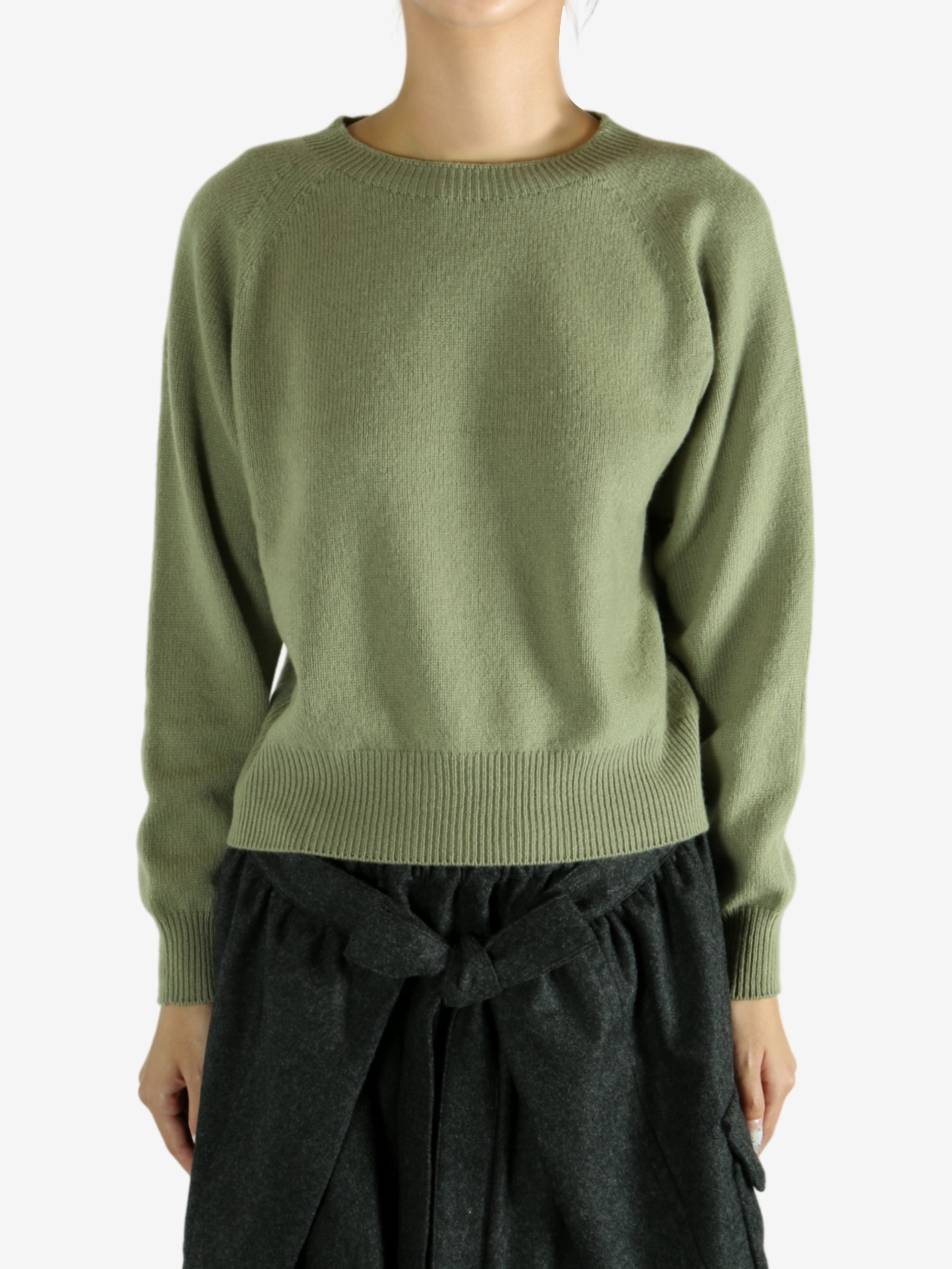 Green knitwear worn by a person, showing the knitwear's fit
