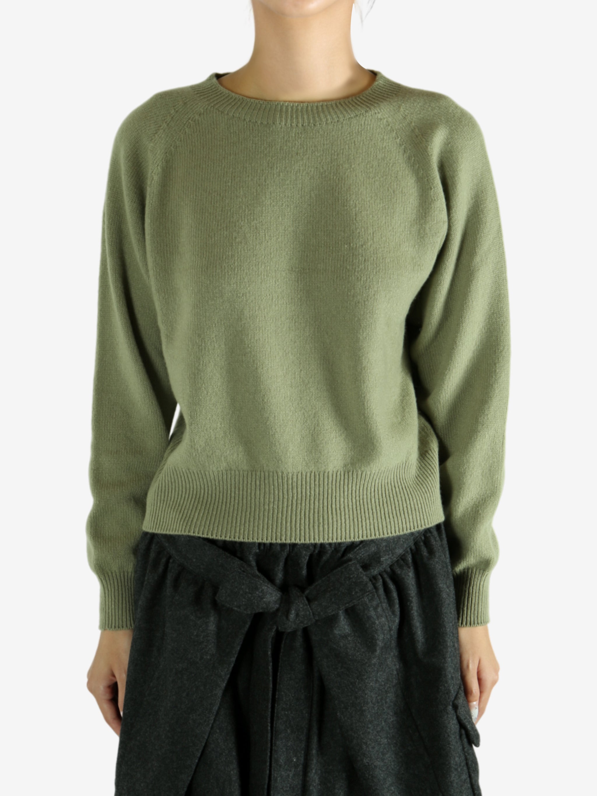 Green knitwear worn by a person, showing the knitwear's fit