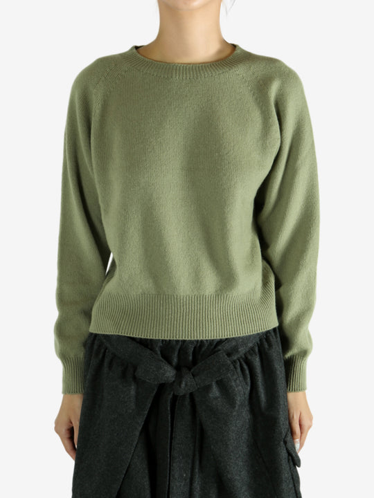 Green knitwear worn by a person, showing the knitwear's fit