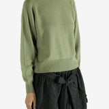 Green knitwear worn by a person, showing the knitwear's fit