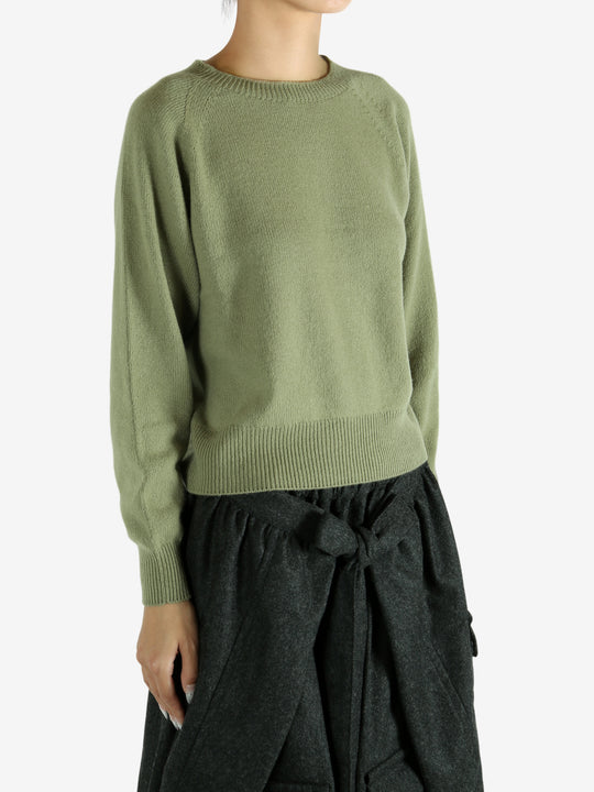 Green knitwear worn by a person, showing the knitwear's fit