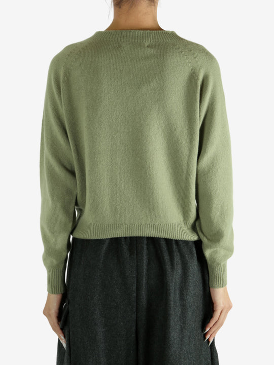 Green knitwear worn by a person, showing the knitwear's fit