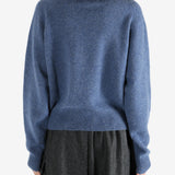 Navy knitwear worn by a person, showing the knitwear's fit