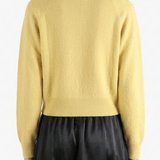 Yellow knitwear worn by a person, showing the knitwear's fit
