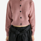 pink knitwear worn by a person, showing the knitwear fit