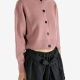 pink knitwear worn by a person, showing the knitwear fit