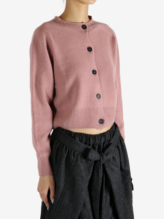 pink knitwear worn by a person, showing the knitwear fit