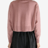 pink knitwear worn by a person, showing the knitwear fit