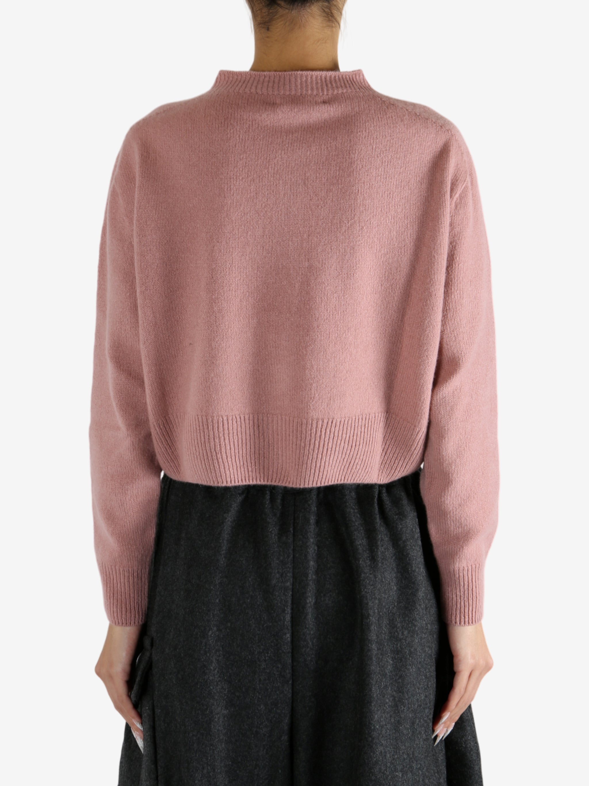 pink knitwear worn by a person, showing the knitwear fit