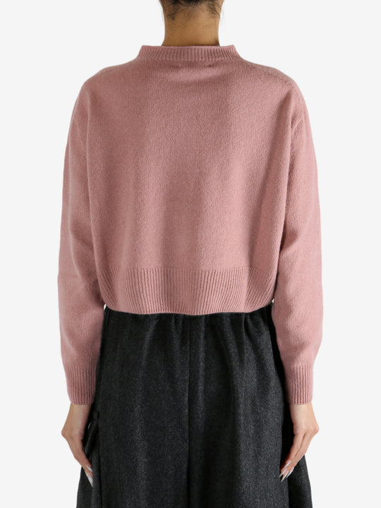 pink knitwear worn by a person, showing the knitwear fit