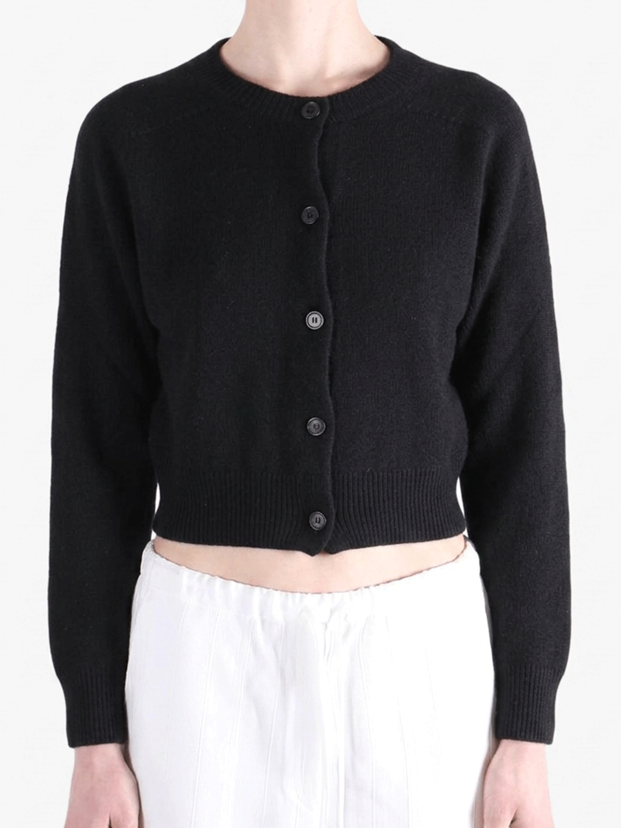 Black knitwear worn by a person, showing the knitwear's fit