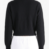 Black knitwear worn by a person, showing the knitwear's fit