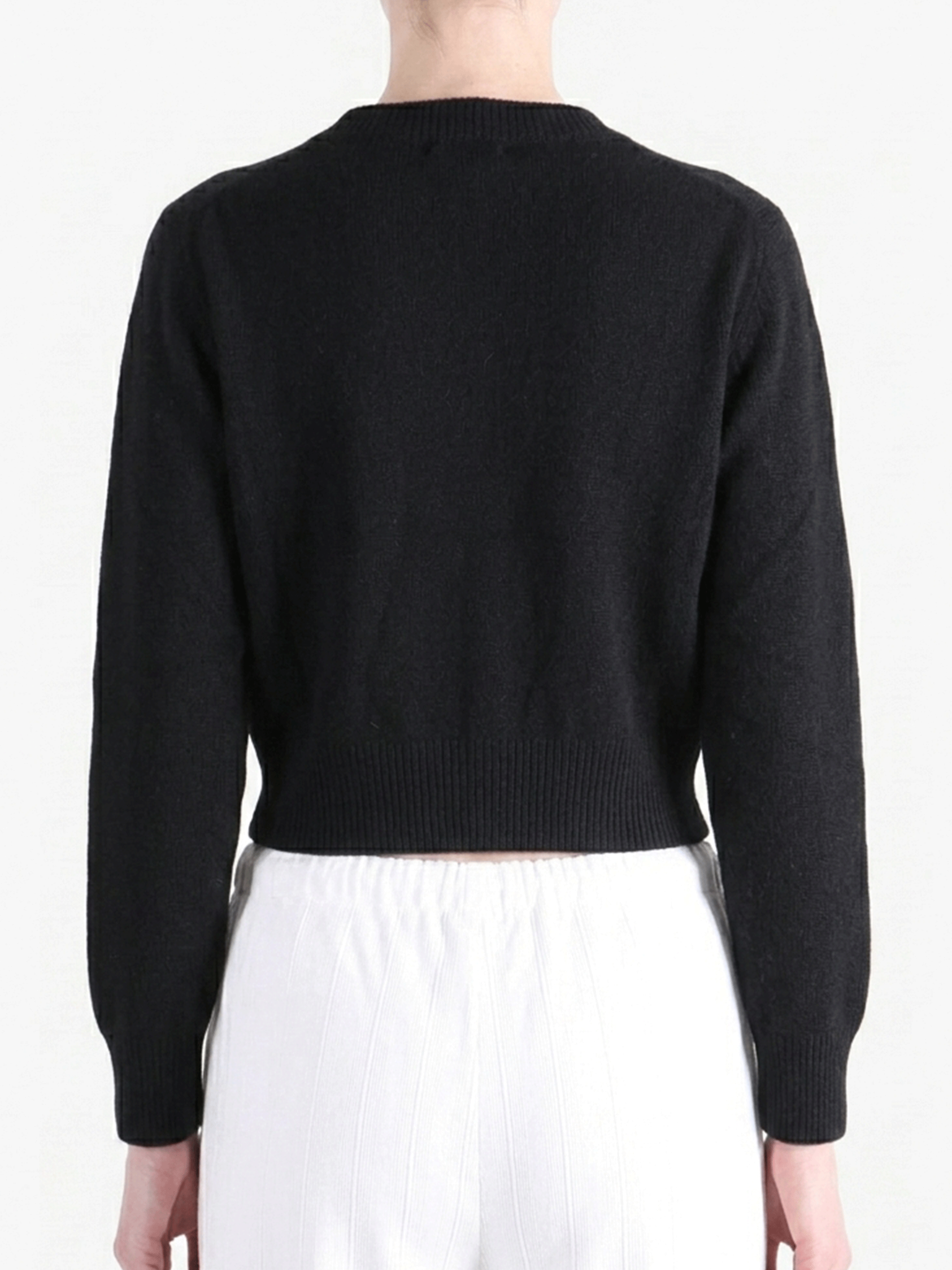 Black knitwear worn by a person, showing the knitwear's fit