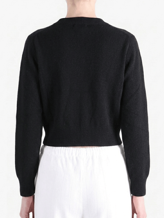 Black knitwear worn by a person, showing the knitwear's fit