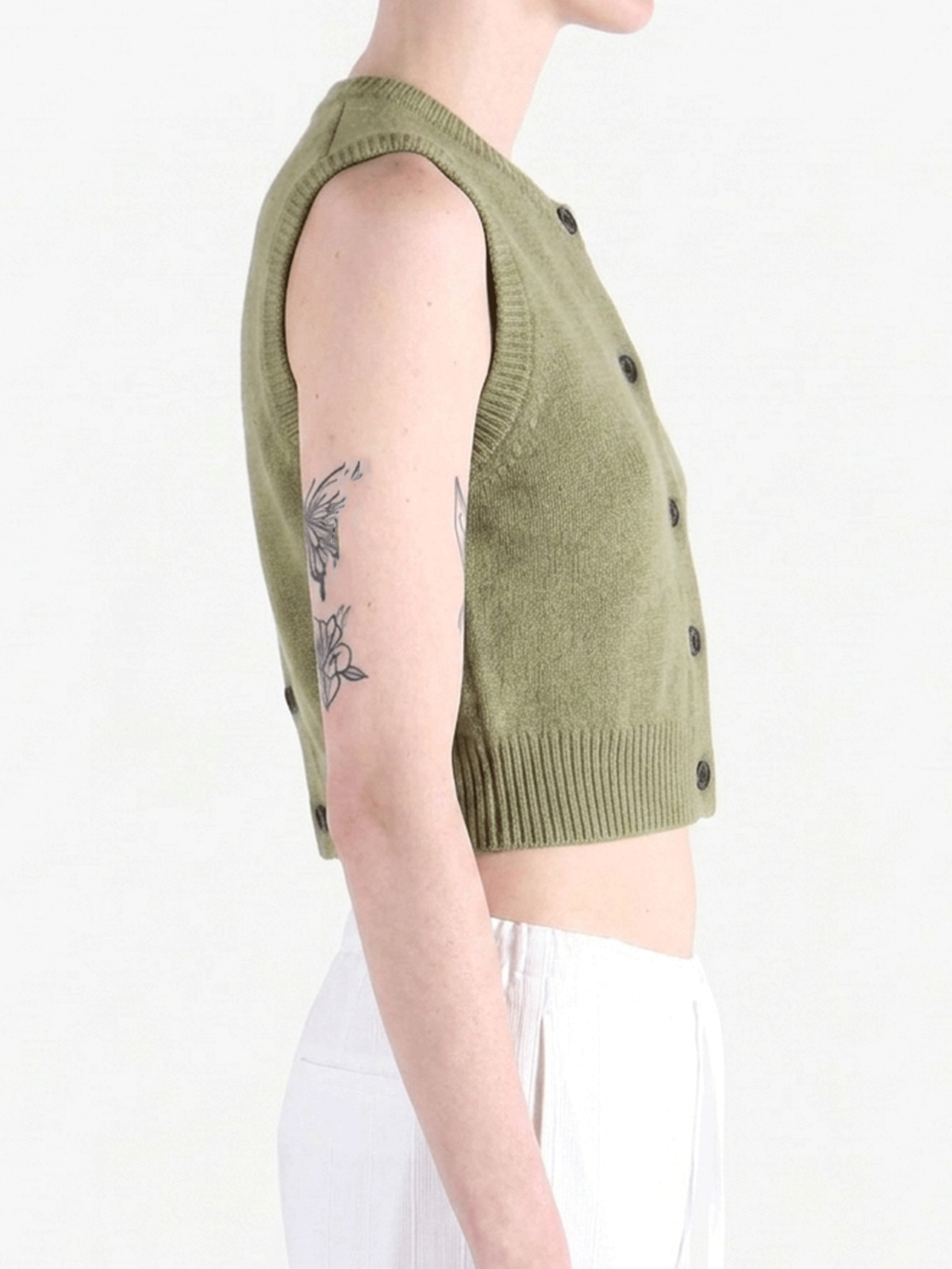 Green top worn by a person, side view