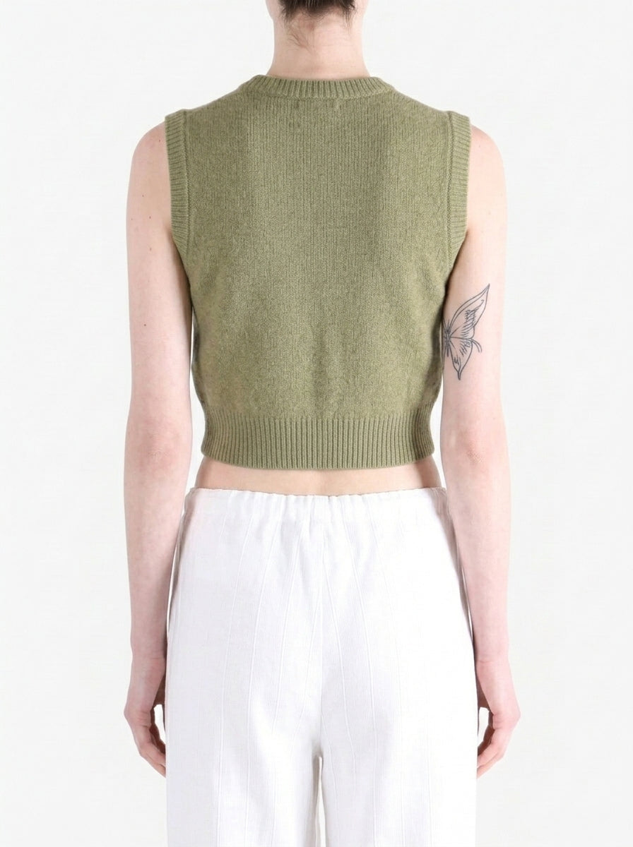 Green top worn by a person, back view