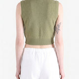 Green top worn by a person, back view