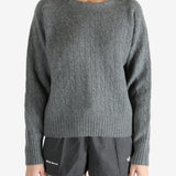 Grey knitwear worn by a person, showing the knitwear fit