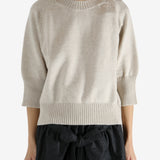 tan knitwear worn by a person, showing the knitwear fit