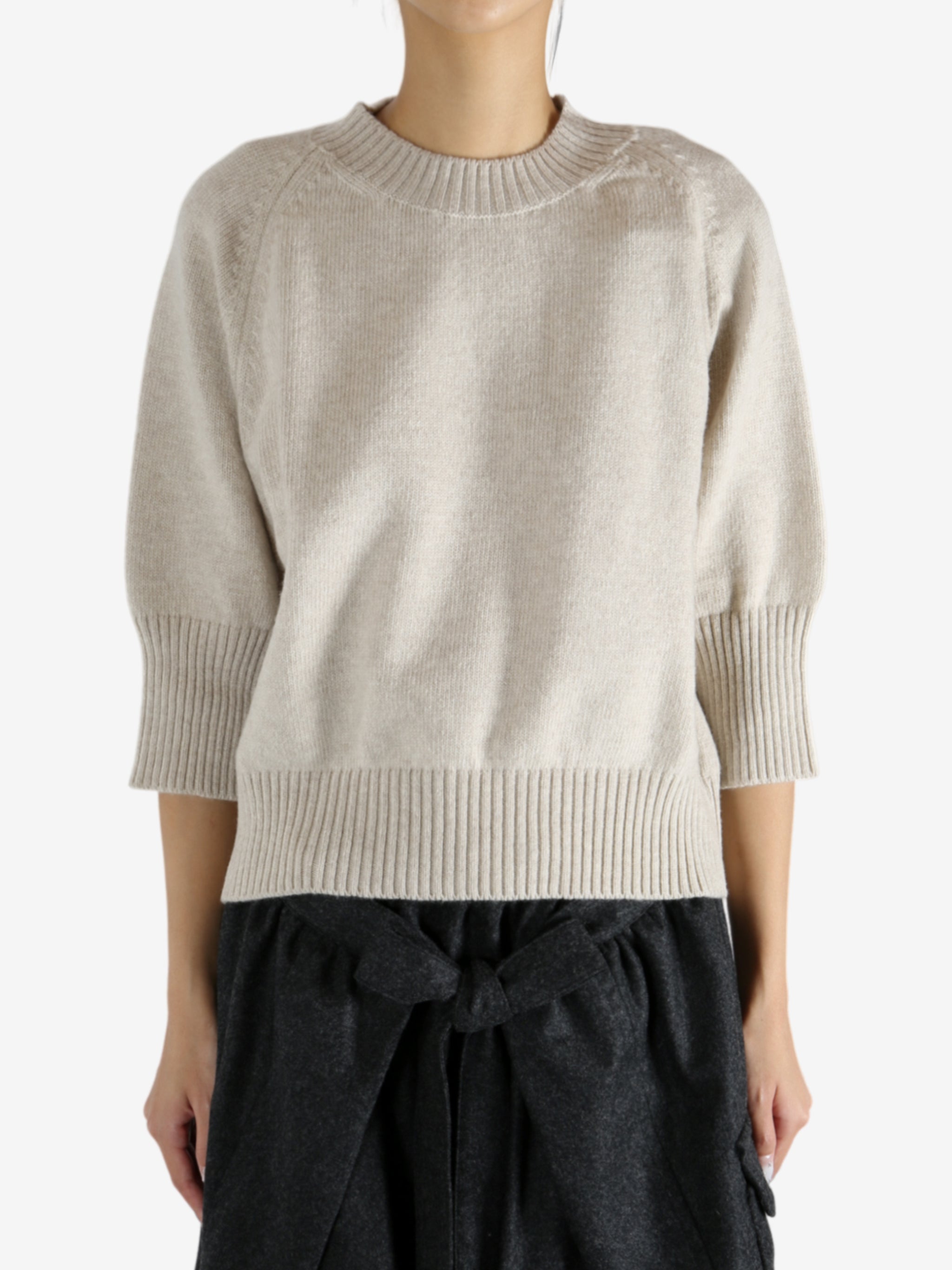 tan knitwear worn by a person, showing the knitwear fit