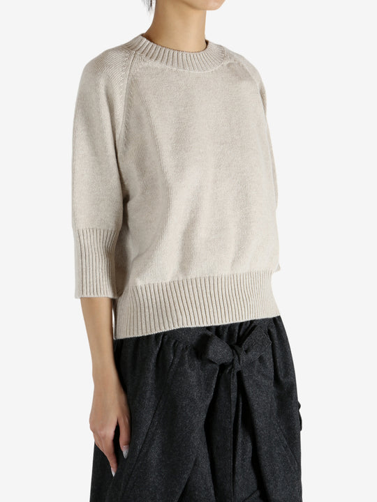 tan knitwear worn by a person, showing the knitwear fit