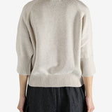 tan knitwear worn by a person, showing the knitwear fit