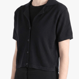 Black shirt worn by a person, showing the shirt's fit