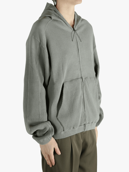 Grey hoodie worn by a person, showing the hoodie's fit