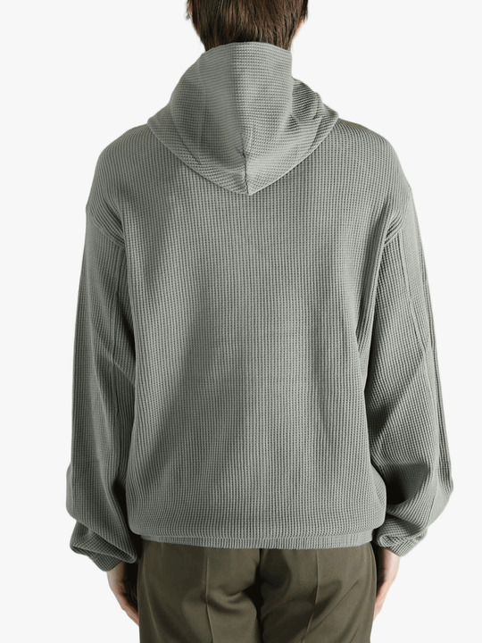 Grey hoodie worn by a person, showing the hoodie's fit