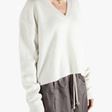 White sweater worn by a person, showing the sweater fit