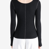 Black knitwear worn by a person, showing the knitwear fit