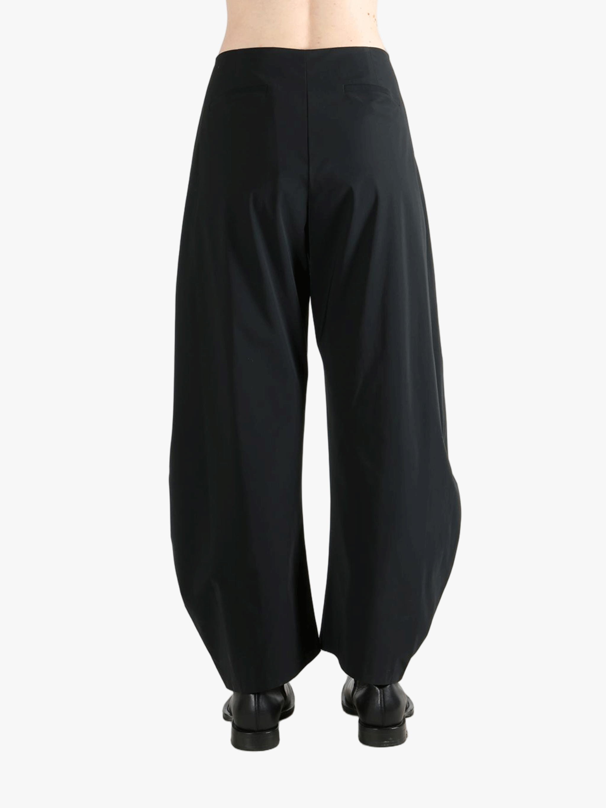 Black pants worn by a person, showing the pants' fit