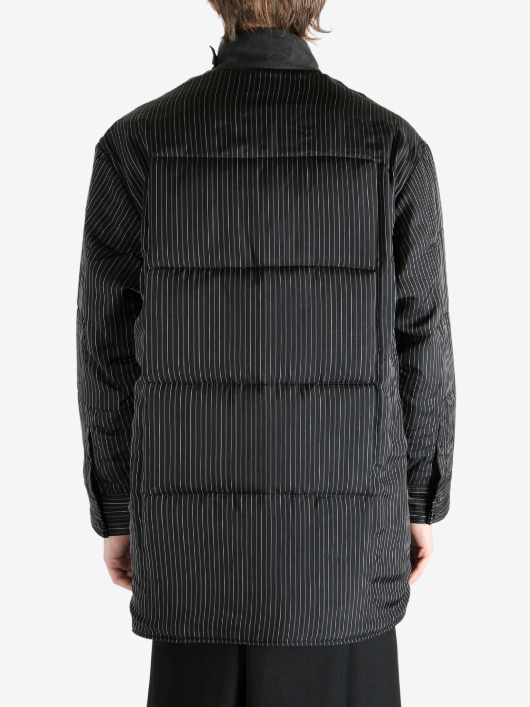 Black coat worn by a person, showing the coat's fit