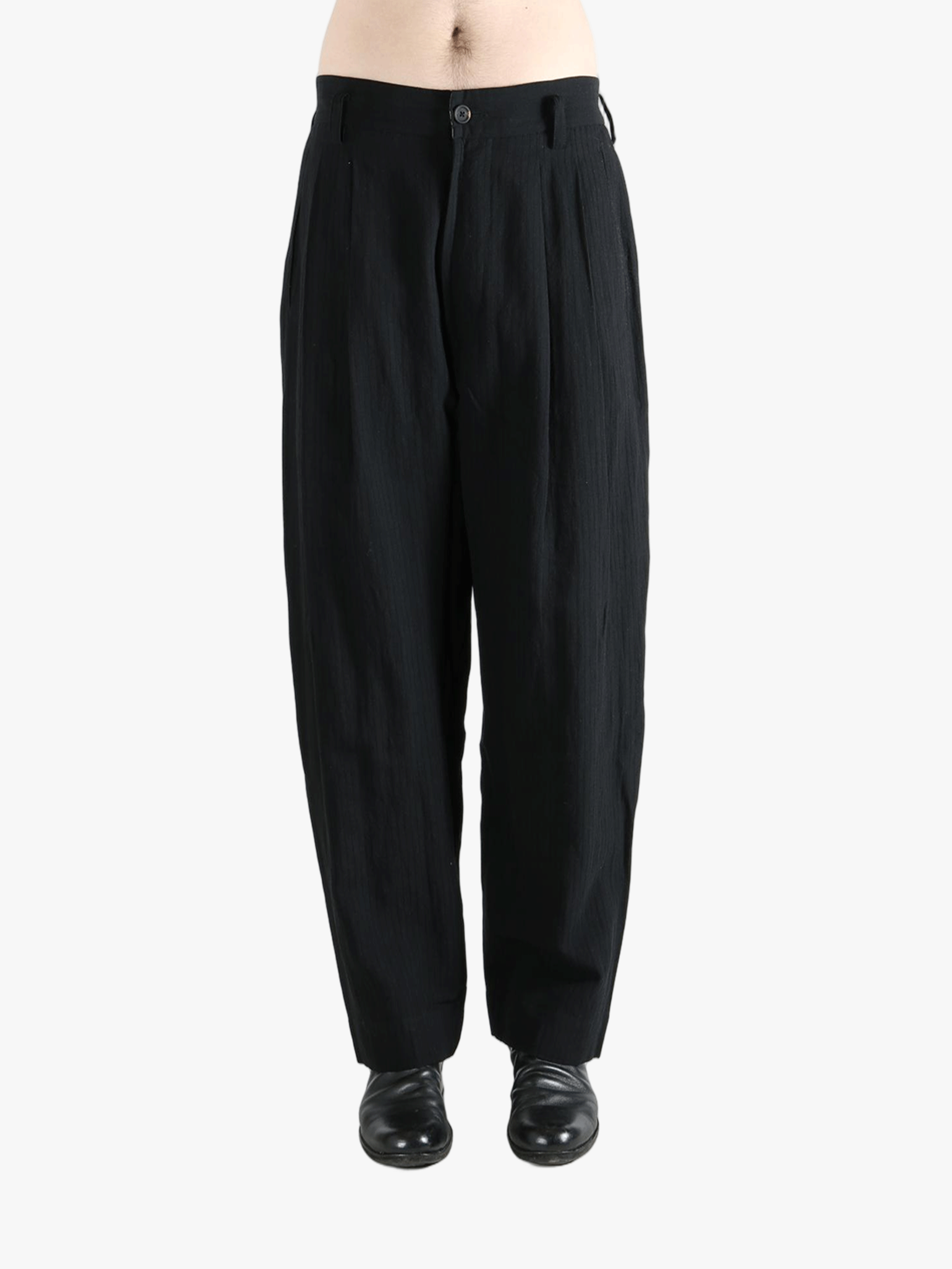 Black pants worn by a person, showing the pants fit