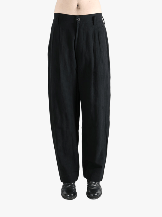 Black pants worn by a person, showing the pants fit