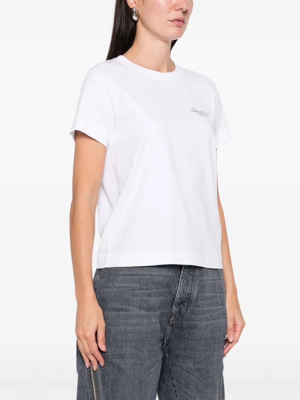 White t-shirt worn by a person, showing the shirt's fit