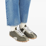 Grey sneakers worn by a person, showing the sneakers's fit