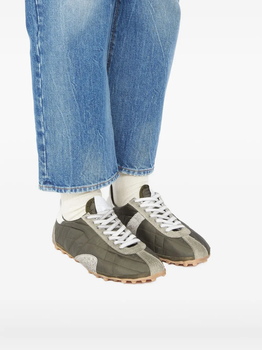 Grey sneakers worn by a person, showing the sneakers's fit