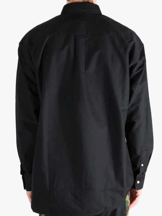Black shirt worn by a person, showing the shirt's fit