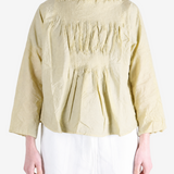 Tan shirt worn by a person, showing the shirt fit