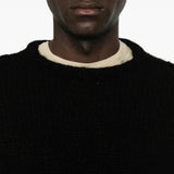 Black knitwear worn by a person, showing the knitwear fit