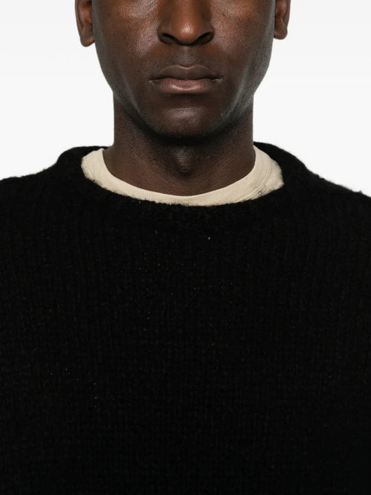 Black knitwear worn by a person, showing the knitwear fit