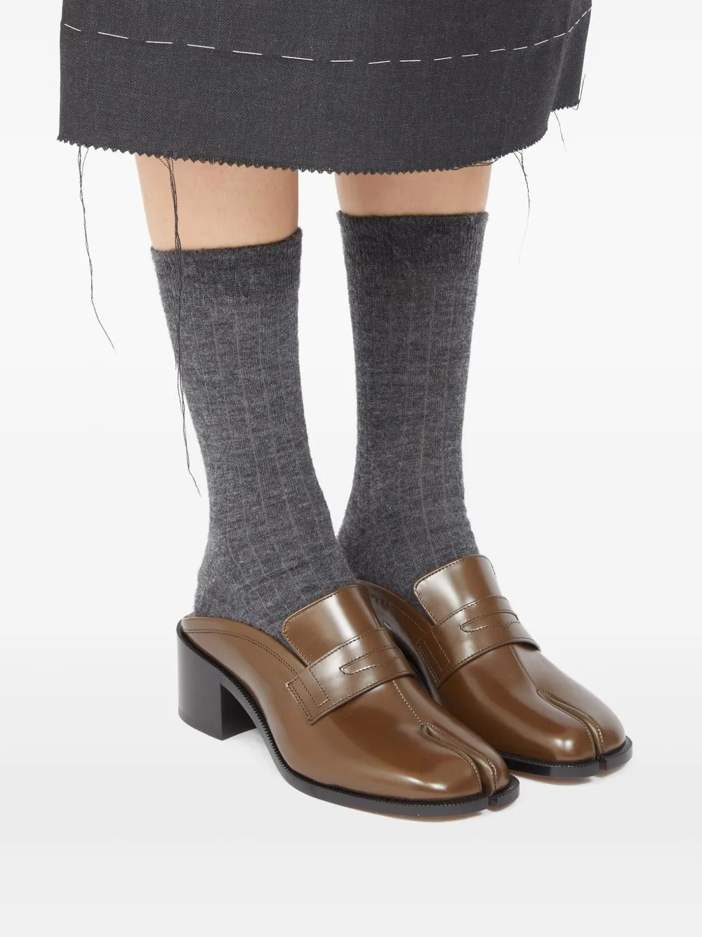 Brown mules worn by a person, showing the mules' fit