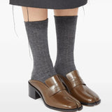 Brown mules worn by a person, showing the mules' fit