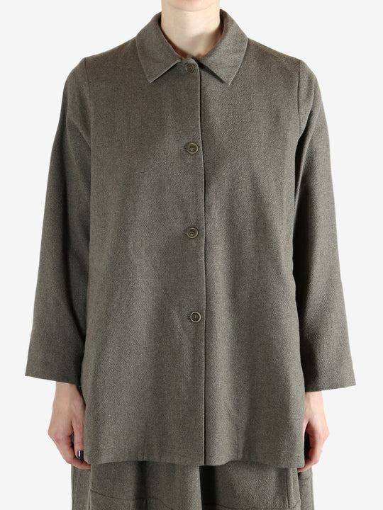 Grey coat worn by a person, showing the coat fit