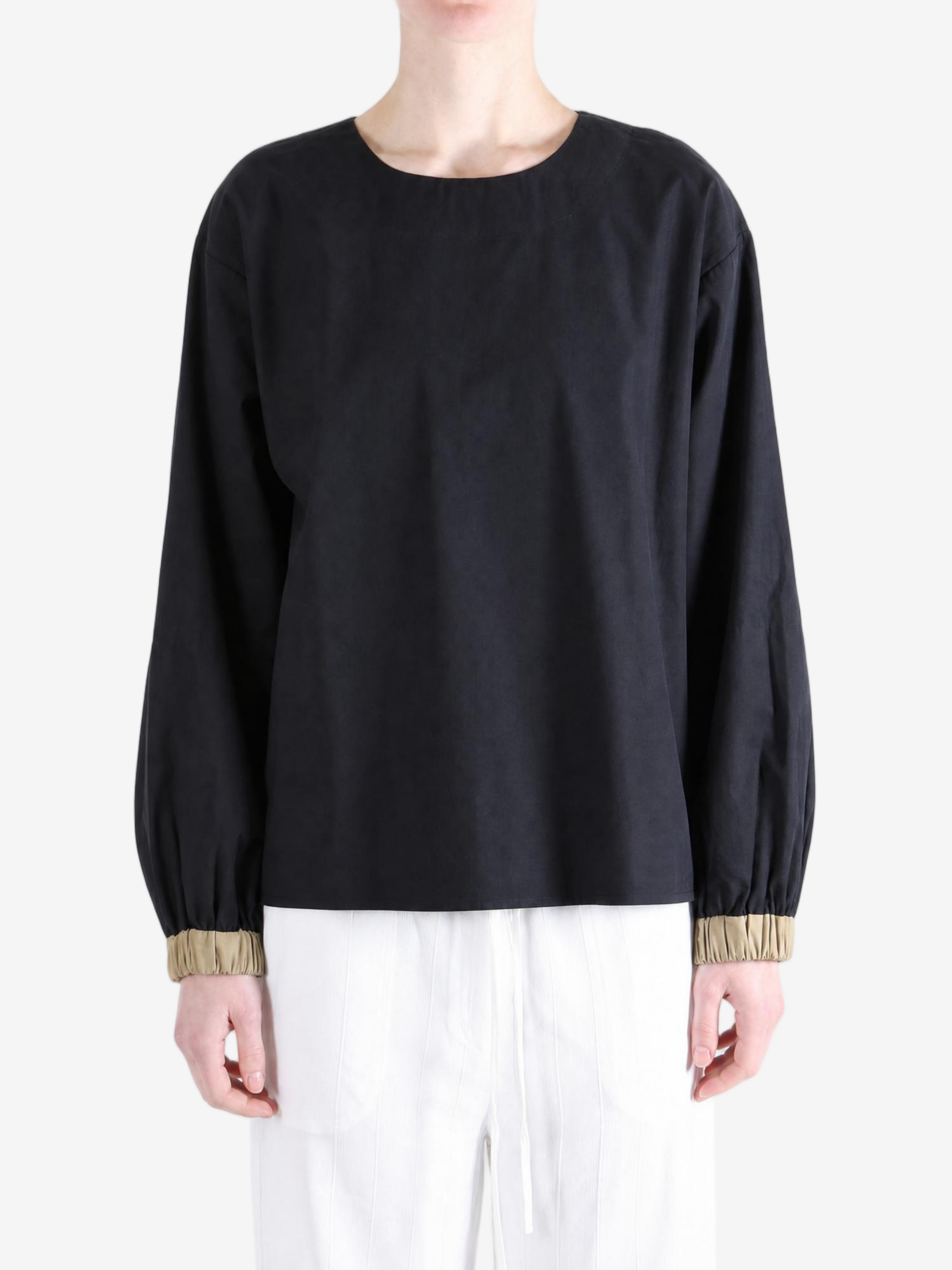 Black top worn by a person, showing the top fit
