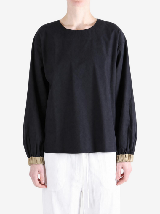 Black top worn by a person, showing the top fit