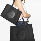 Black tote bag worn by a person, showing the bag fit