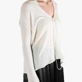 White sweater worn by a person, showing the sweater's fit