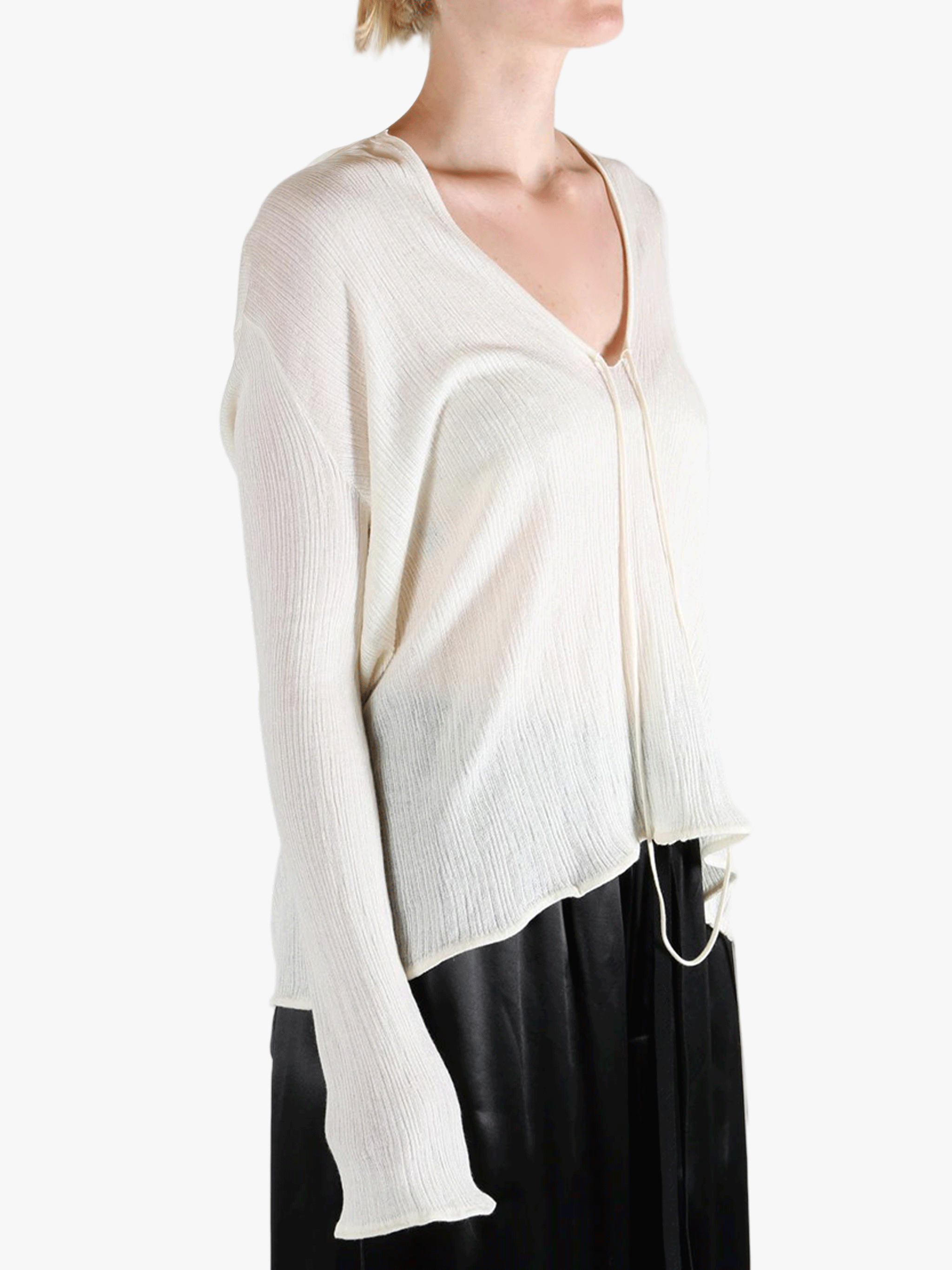 White sweater worn by a person, showing the sweater's fit